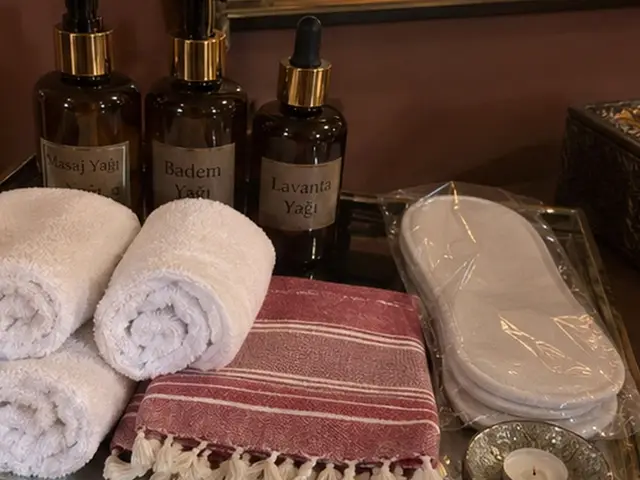 Masaj yağları, rulo havlular, kırmızı çizgili peştemal ve terlik — Güngören, Masaj Salonun